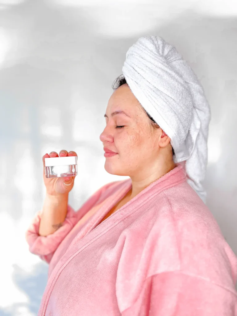 Mulher madura sorrindo segurando o creme facial Hidra Cream após cuidados com a pele